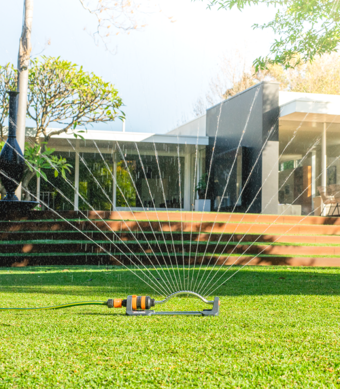 oscillating sprinkler watering lawn