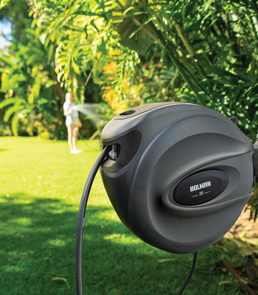 Charcoal 20m Retractable Hose Reel installed in garden with charcoal coloured side insert